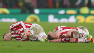 Stoke City FC players Marko Arnautovic and Charlie Adam lie injured during a Premier League match.