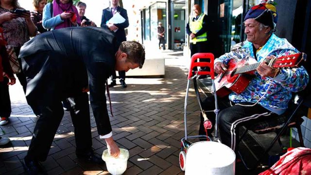 Passer-by donates money to a busker