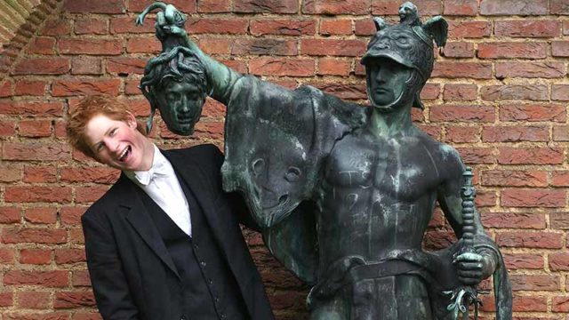 A young Prince Harry poses next to a statue of Perseus in 2003 at Eton College, England. Pic: Getty