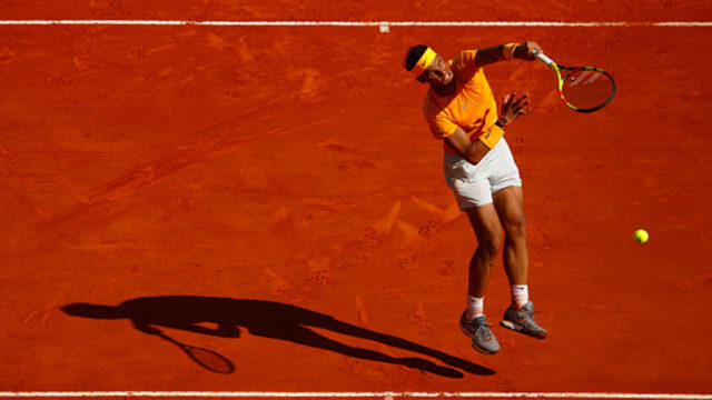 Rafael Nadal goes for a smash in his match against Kei Nishikori of Japan during day eight of ATP Masters Series: Monte Carlo Rolex Masters.