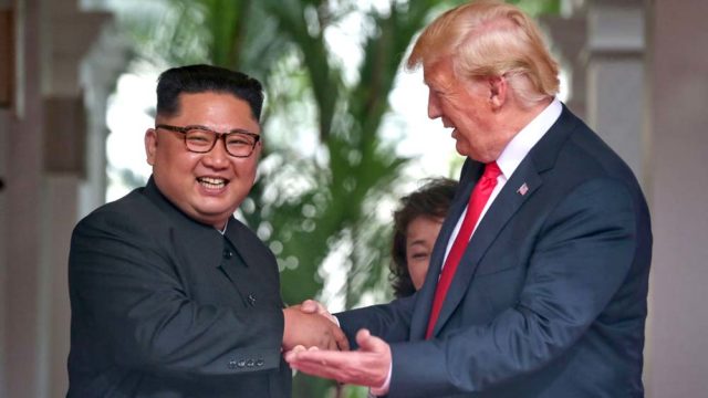 North Korean leader Kim Jong-un shakes hands with President Donald Trump during their historic summit in Singapore today. Pic: Getty