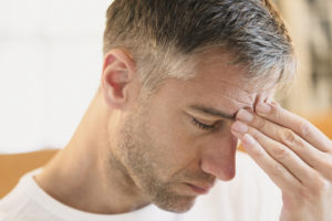 Close up of man with headache touching forehead. Pic: Getty