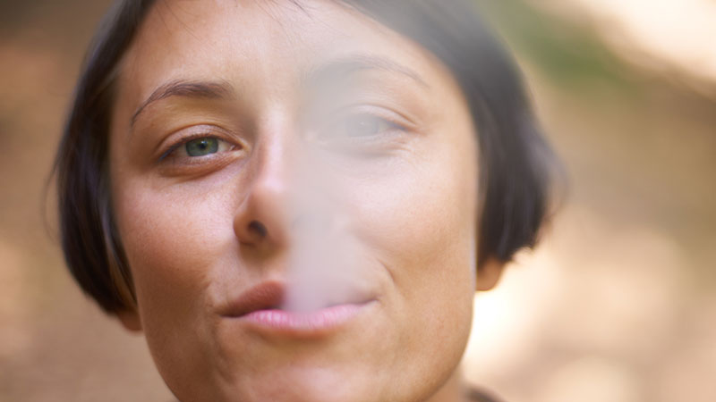 A woman blows smoke out of her mouth. Pic: Getty