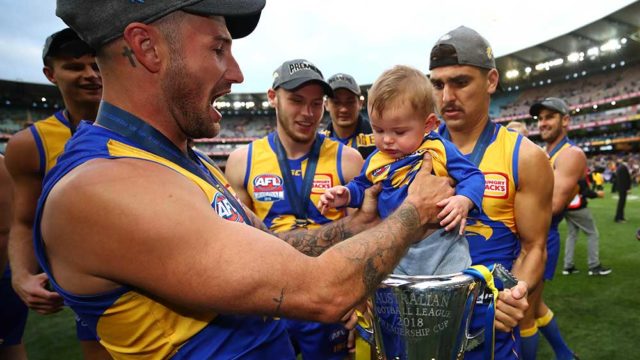 West Coast Eagle Chris Masten places his son in the 2018 AFL Premiership Cup. Pic: Cameron Spencer / AFL Media