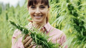 A young smiling woman in a cannabis or marijuana or hemp field. Pic: Getty