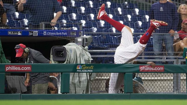 Maikel Franco of the Philadelphia Phillies falls over the camera fence reaching for a foul ball. Image: Getty